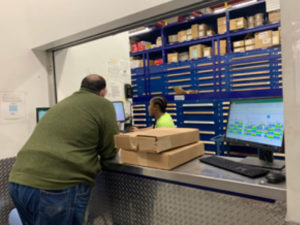 Worker at parts counter picking up boxes