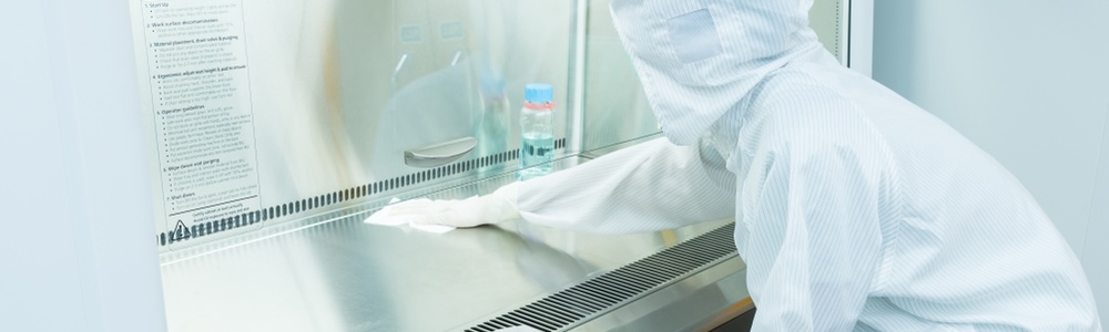 A scientist in sterile coverall gown